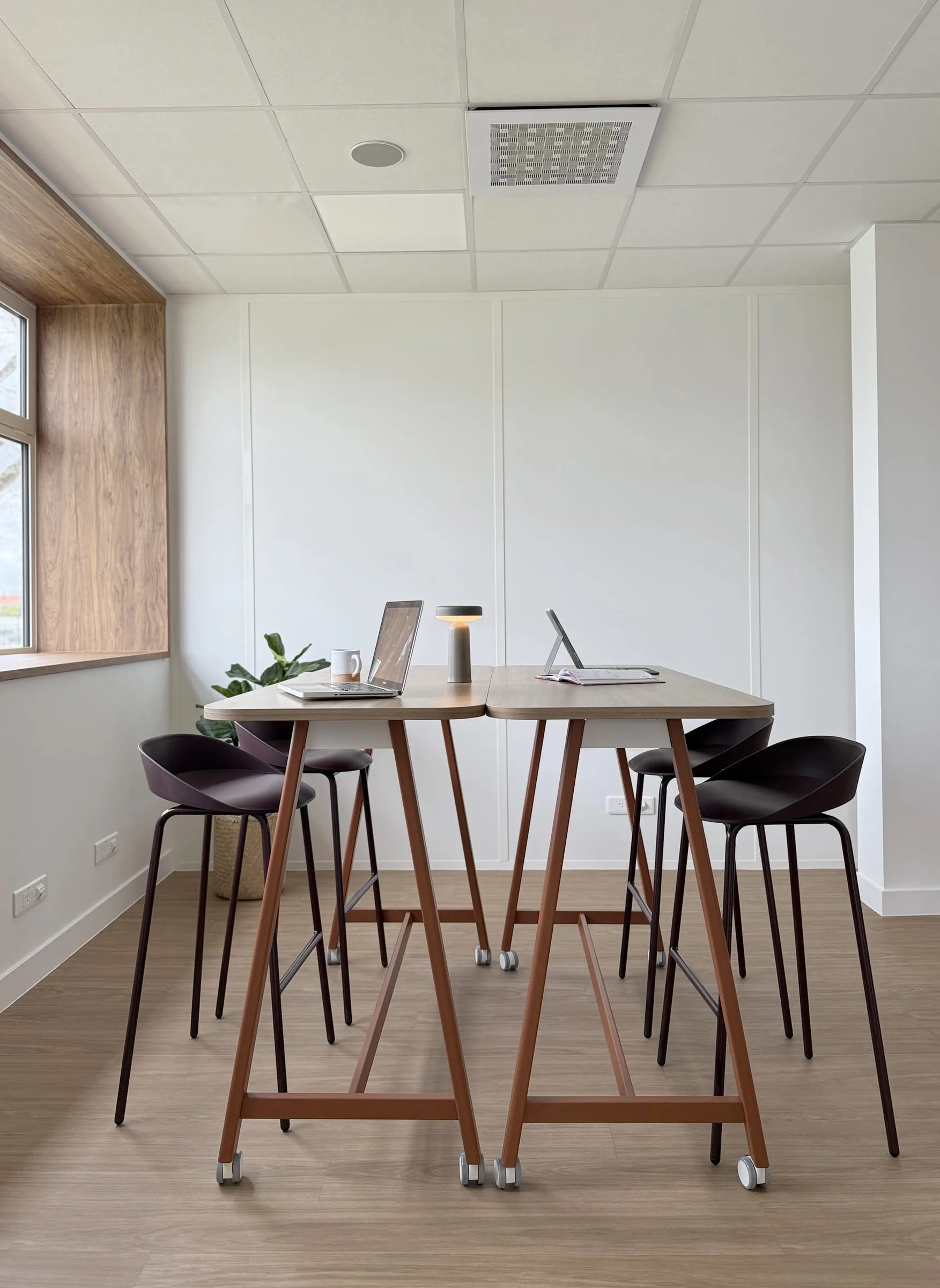 Table haute et tabourets devant une baie vitrée, espace de formation ATR, Blagnac