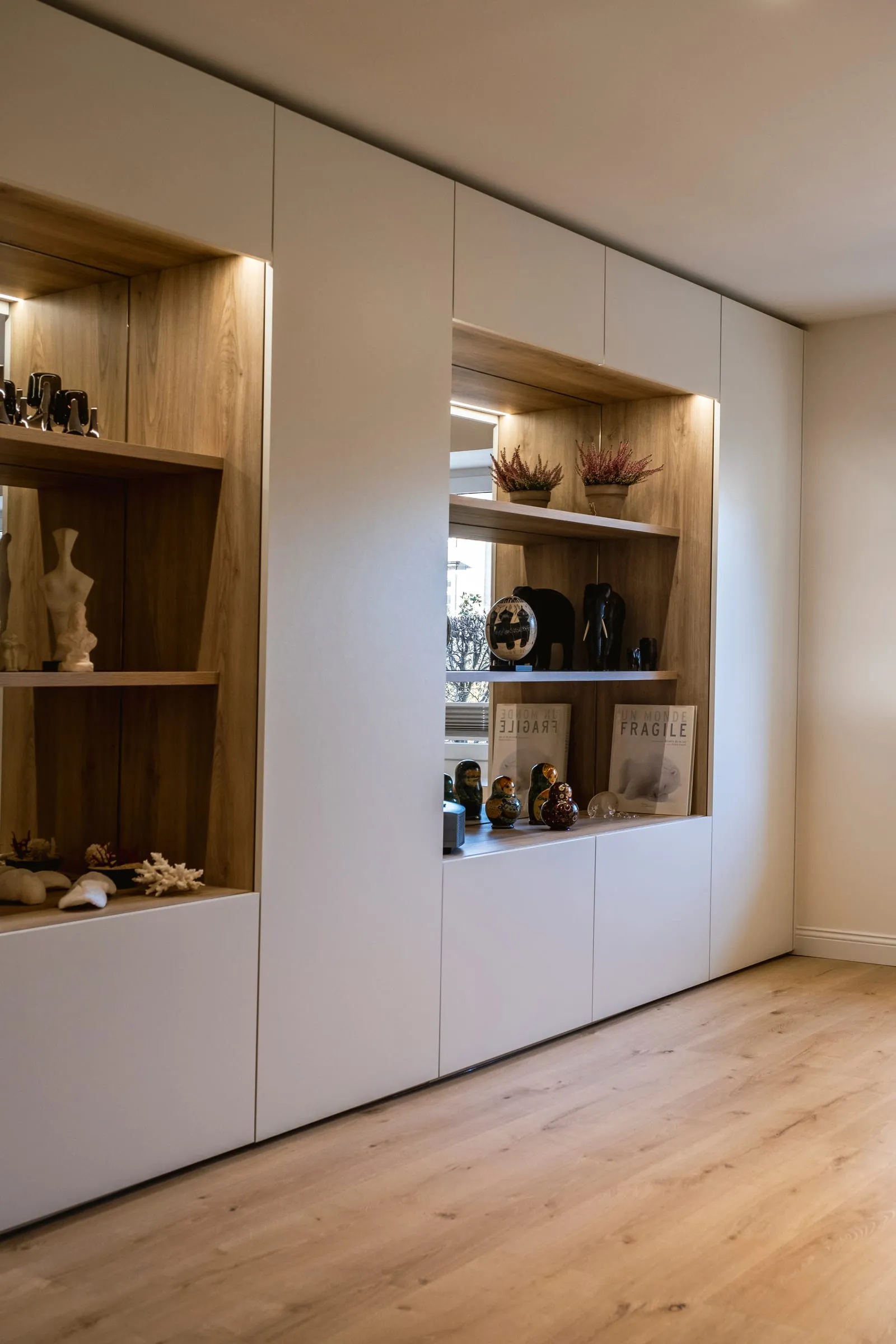 Meuble de séjour sur mesure, niches en bois éclairées et façades laquées blanches, projet Duparchy