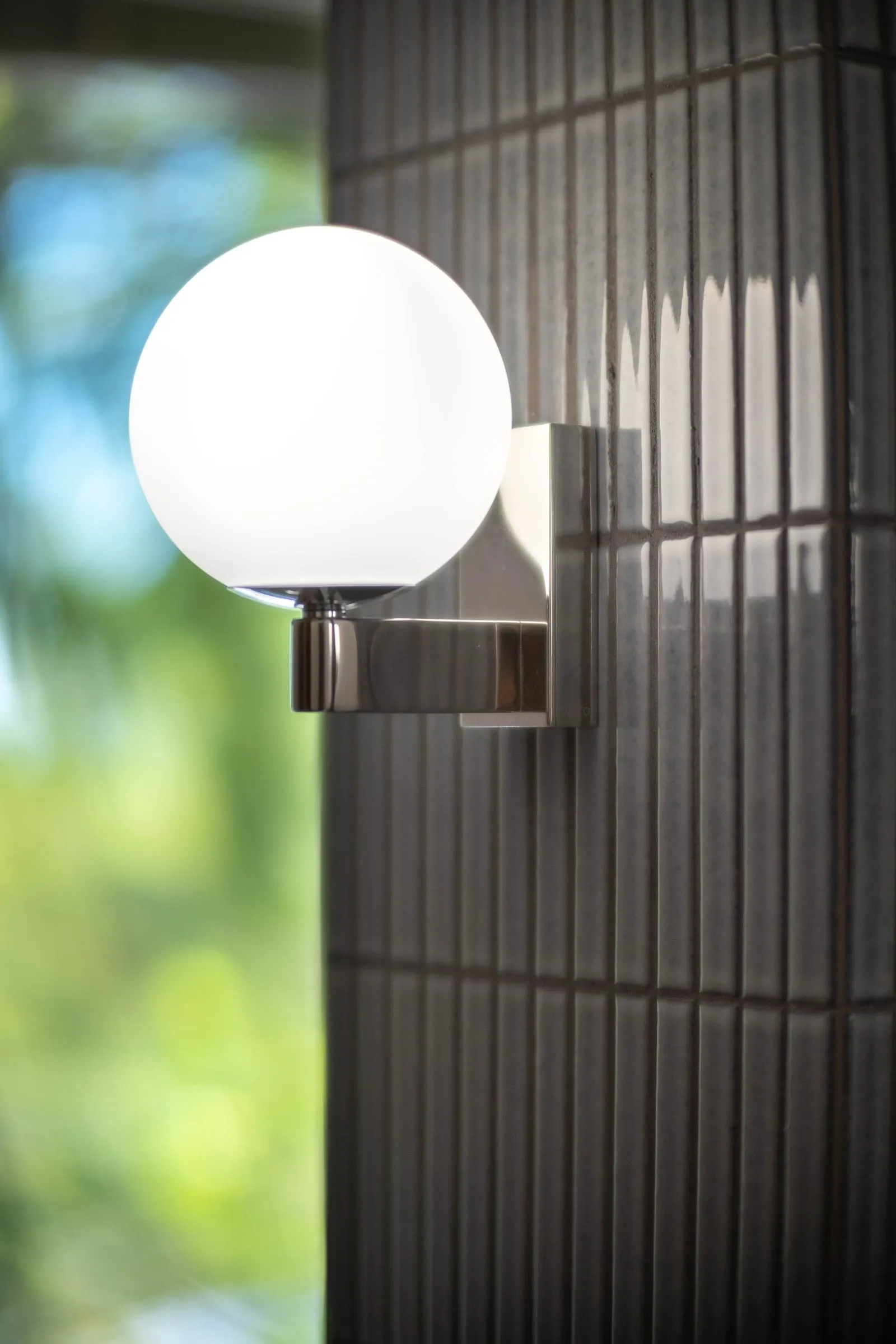 Applique globe chromée sur carrelage strié noir, salle de bain D1
