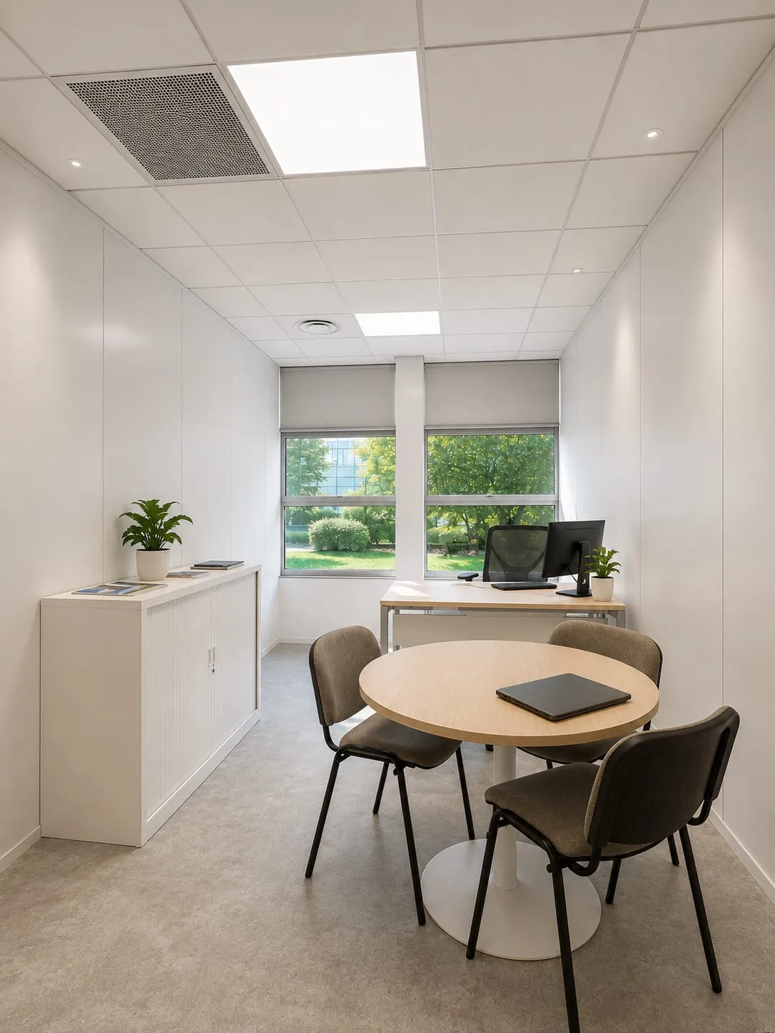 Petit bureau de réunion, table ronde et chaises vertes, CMCAS