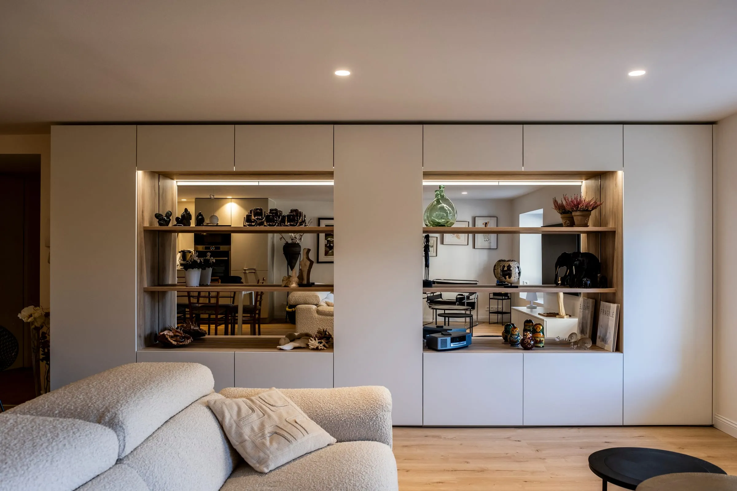 Séjour avec canapé bouclé et meuble sur mesure aux niches en bois, Duparchy
