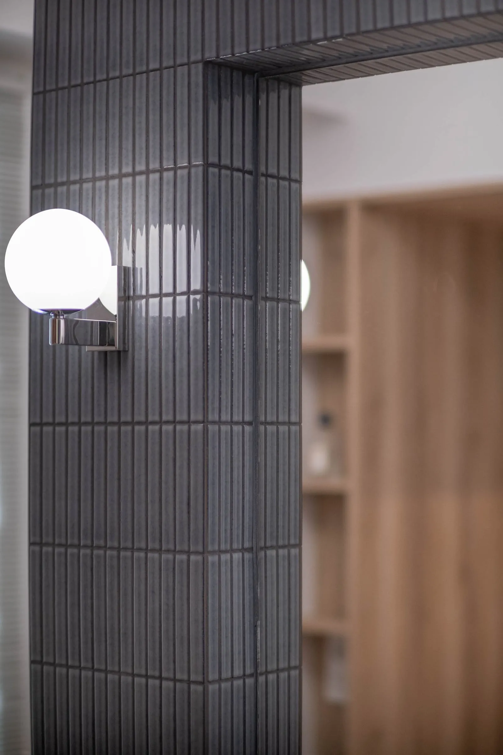 Passage entre la salle de bain en carrelage noir et le dressing en chêne, D1