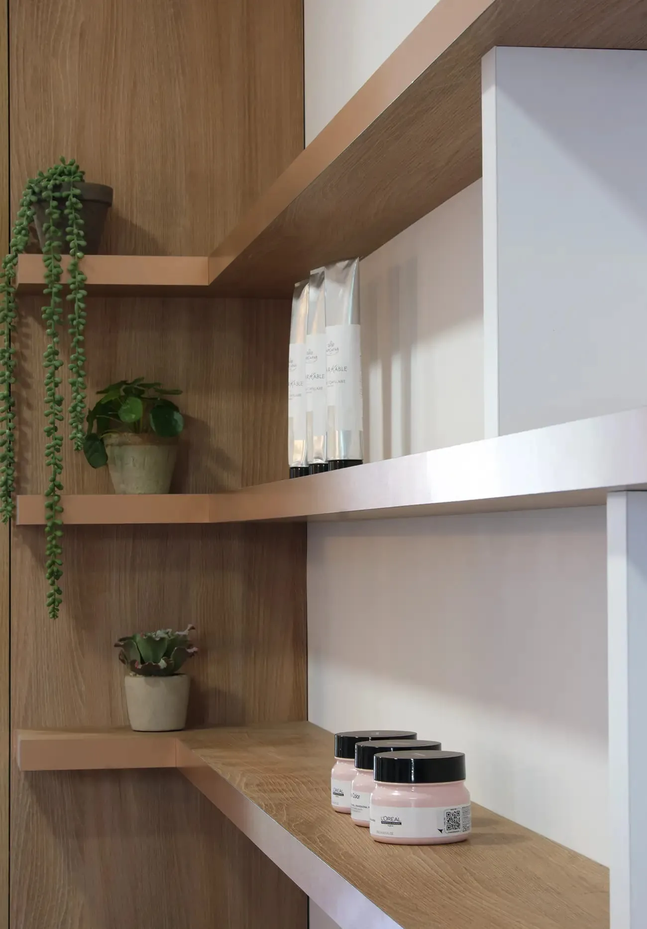 Étagères en chêne avec produits de soin et plantes, Pourquoi Ailleurs