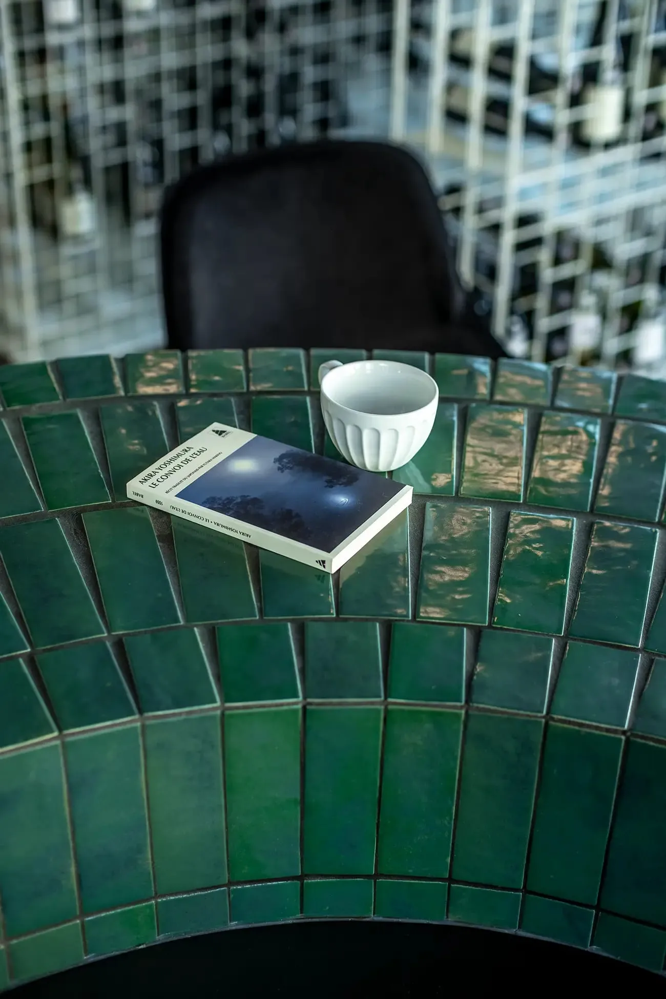 Détail du comptoir en zellige vert émeraude, tasse et livre, L'Atypique