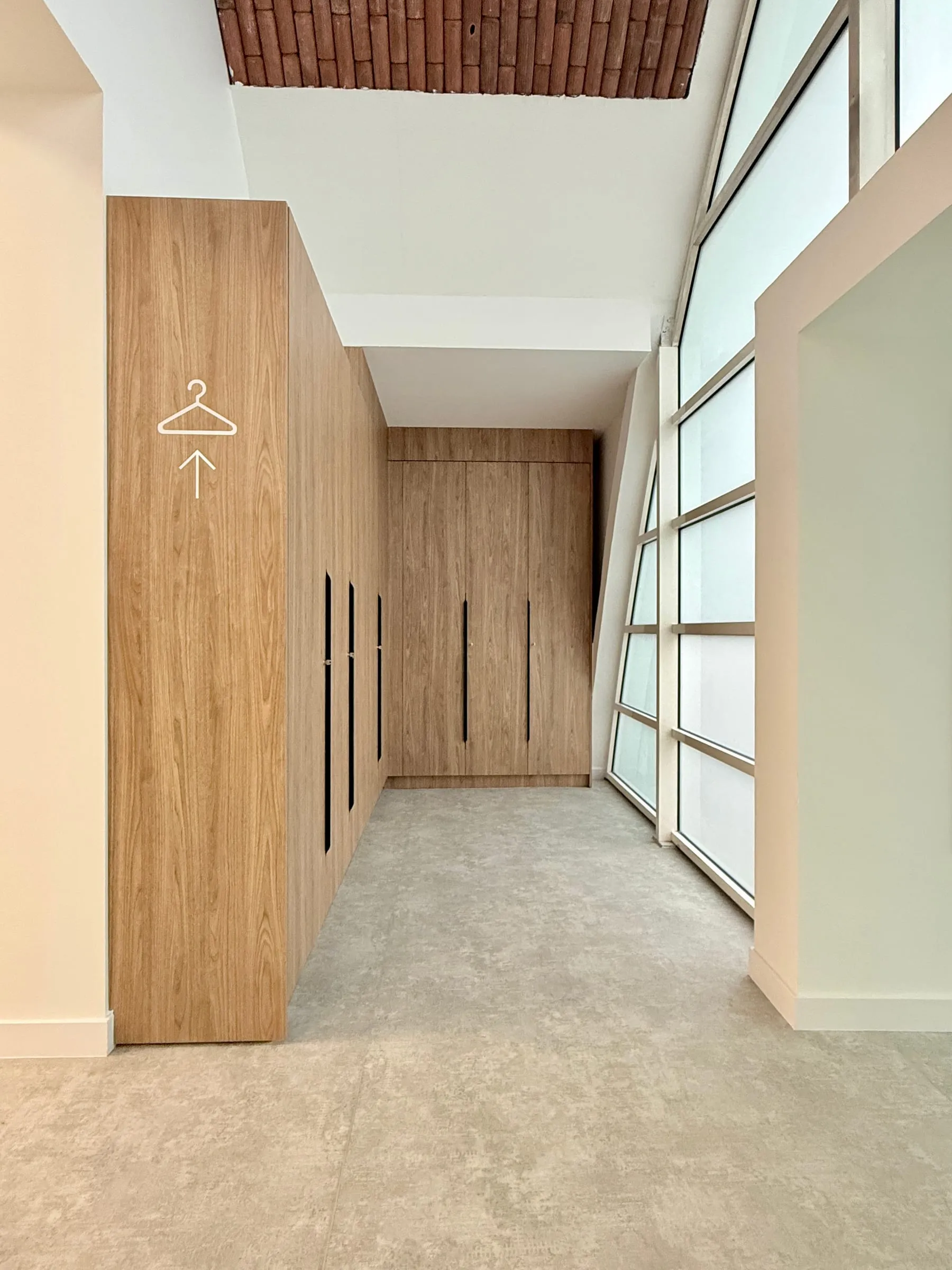 Vestiaires en bois clair sous la verrière, pictogramme cintre, ATR, Blagnac