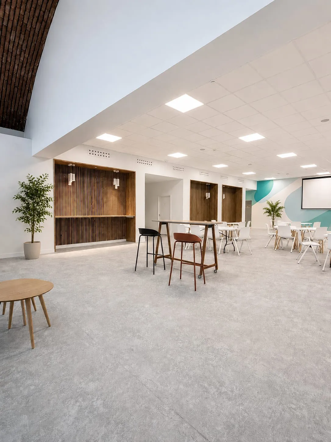 Espace ouvert modulable, tables hautes et fauteuils, mur bois et touches turquoise, ATR