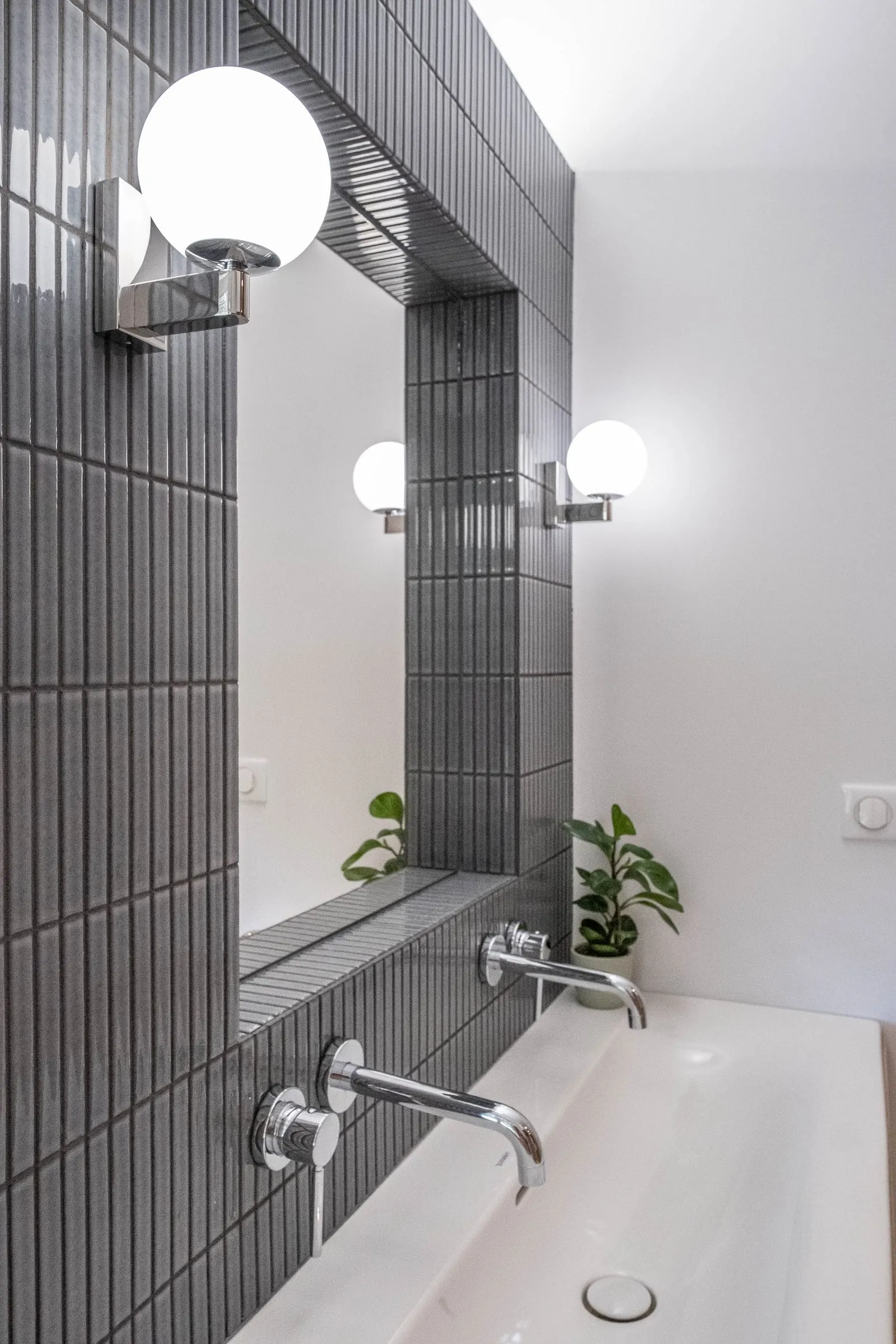 Baignoire en carrelage noir, applique globe et plante, D1